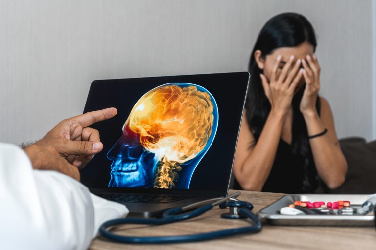 Doctor showing a x-ray of pain in the brain on a laptop. Migraine Headache