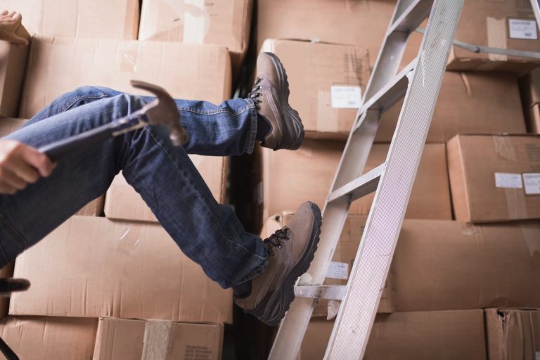 Worker falling off ladder in warehouse