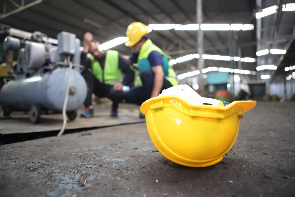 Accident at work of construction worker at site. Safety team helps employee accident.