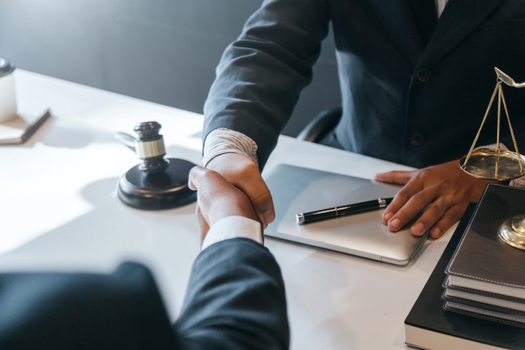 Businessman shaking hands to seal a deal with his partner lawyers or attorneys discussing a contract agreement.