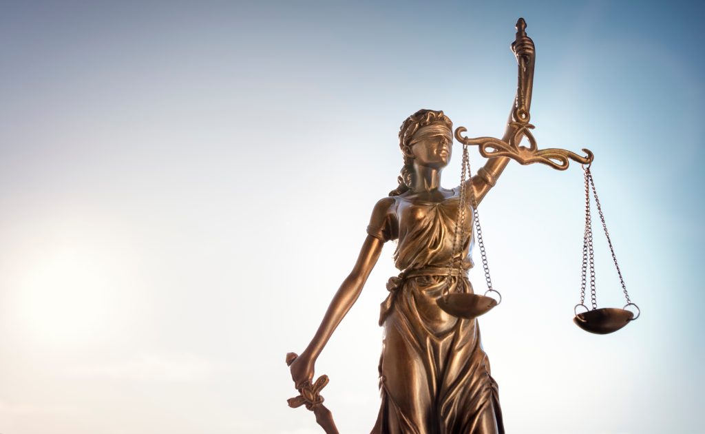 Legal law concept statue of Lady Justice with scales of justice sky background