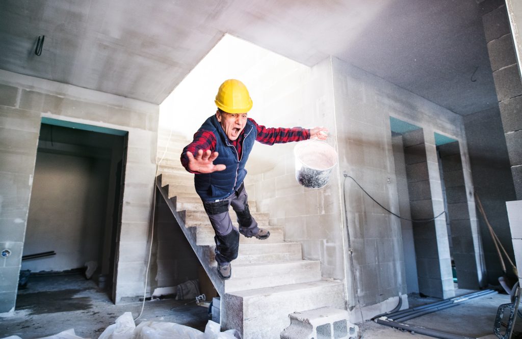 Man falling down the stairs. Accident of a man worker at the construction site. Work injury, accident in workplace.