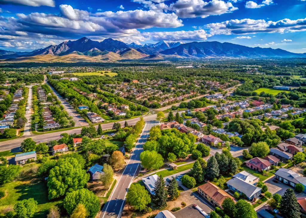 Aerial View of Englewood Colorado Suburb Surrounded by Lush Greenery, Clear Blue Skies, and Majestic Mountain Horizon - Perfect for Nature and Urban Landscape Themes