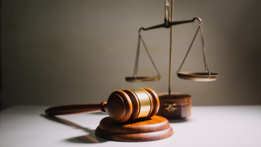 Business and lawyers discussing contract papers with brass scale on desk in office. Law, legal services, advice, justice and law concept