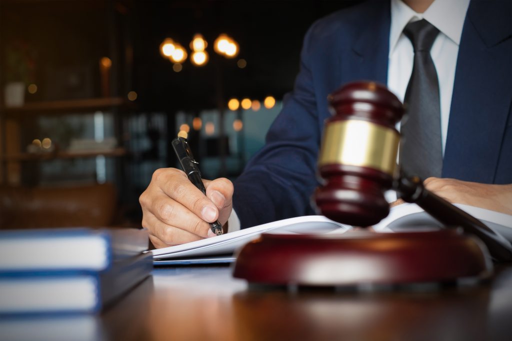 Close up lawyer businessman working or reading lawbook in office workplace for consultant lawyer concept.