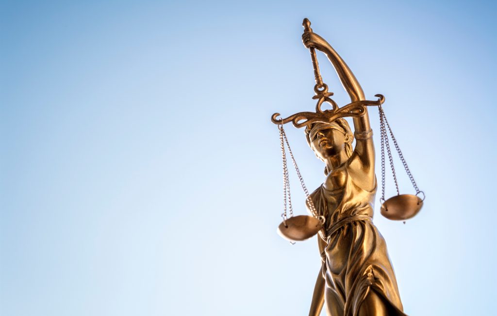 Legal law concept statue of Lady Justice with scales of justice sky background