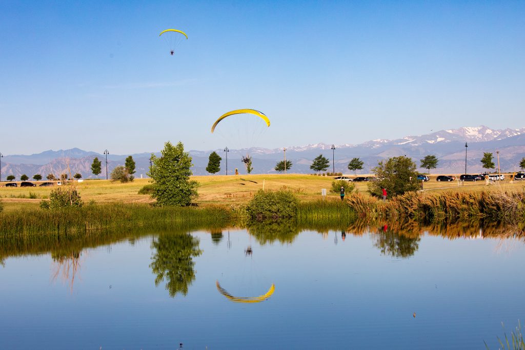 Paraglider flying over lake
