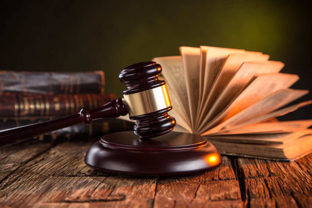 Wooden gavel and books on wooden table, law concept